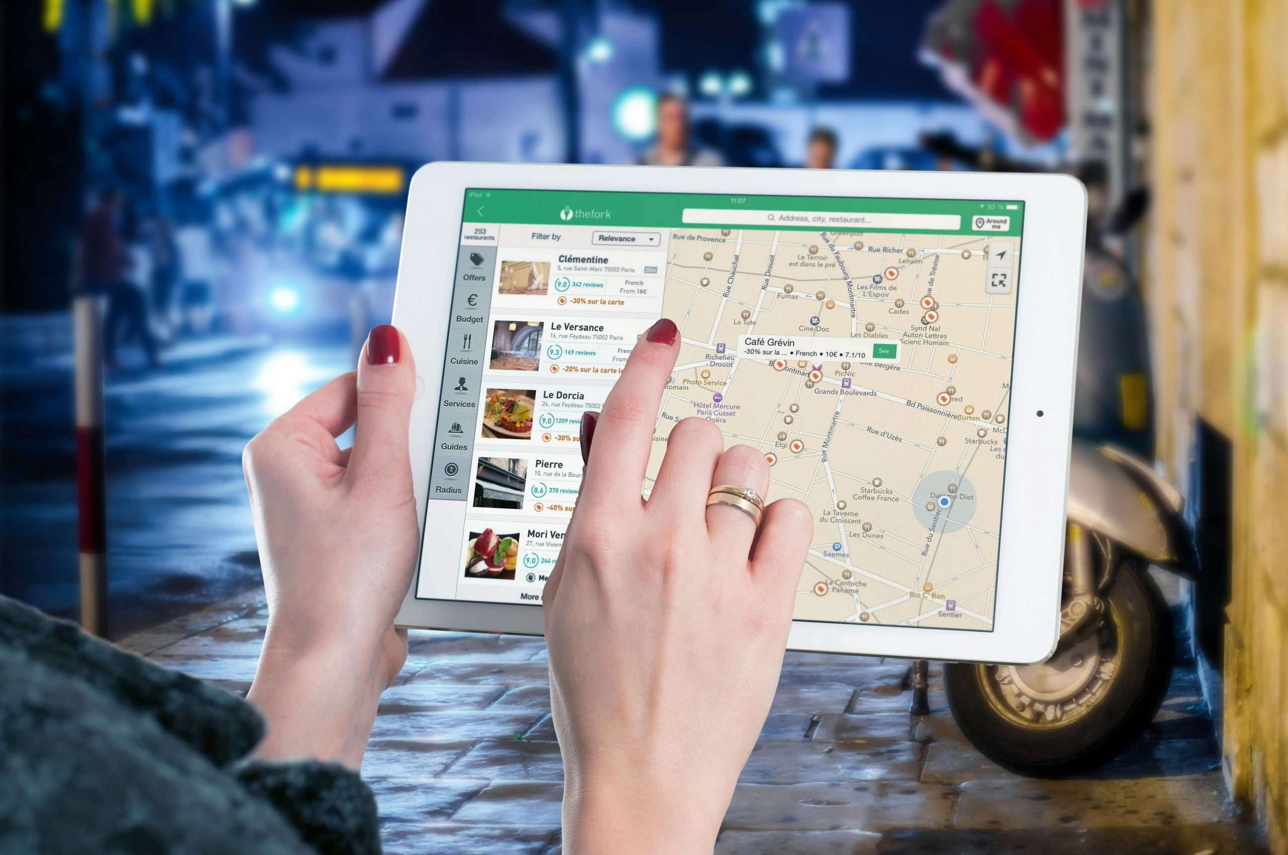 About the Network Hands using a digital map on a tablet in an urban setting at night, illustrating navigation and technology.